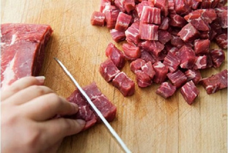 Thịt bò mua về rửa sạch, để ráo, cắt thành những khối vuông nhỏ khoảng 2 cm.